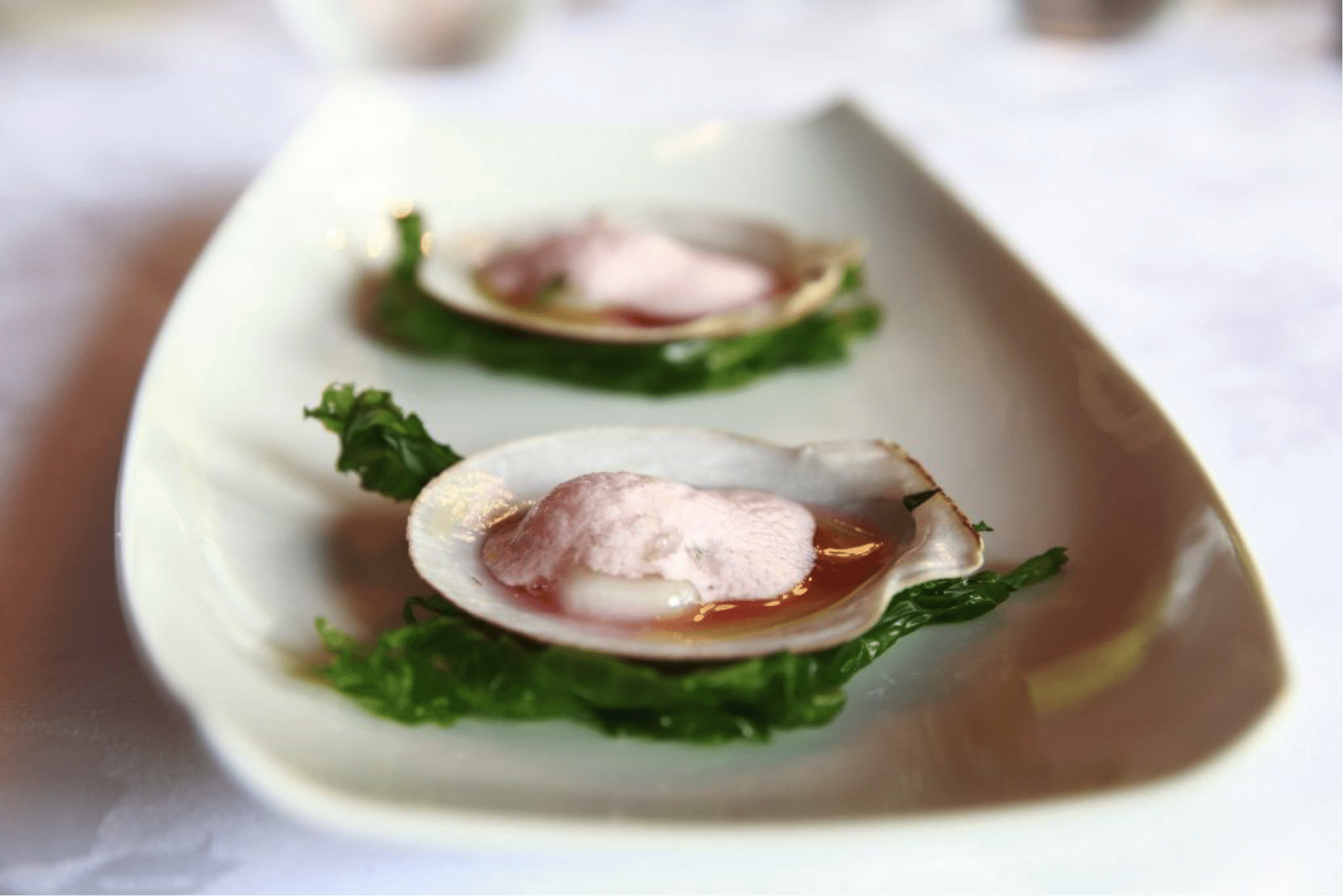 Raw Princess scallops form the Magdalen islands, served on the shell in their refreshing rhubarb water marinade, topped with tarragon-spiked strawberry foam.