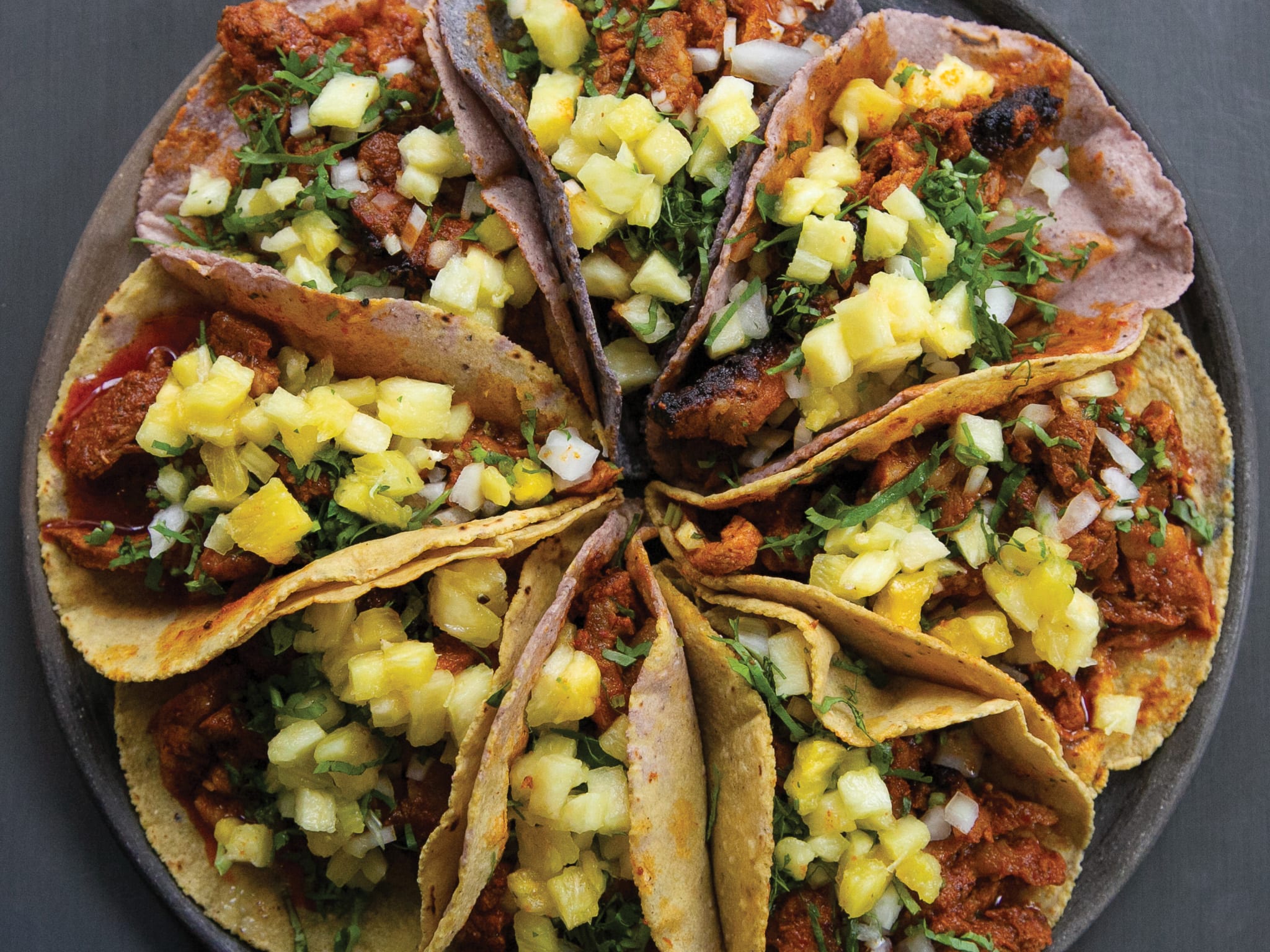 Tacos al pastor with onion, cilantro and fresh pineapple
