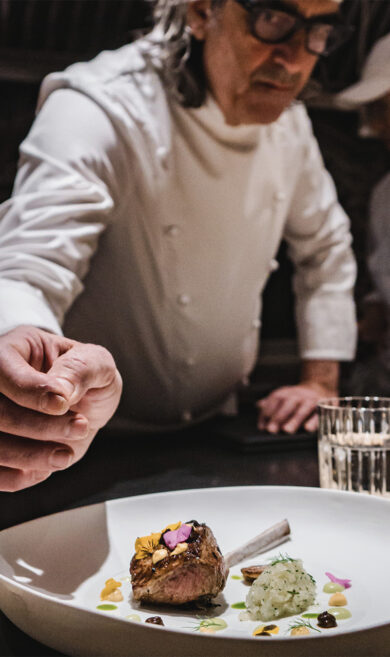LSL chef Leroy finishing a dish of lamb with jalapeño sauce, Japanese black garlic, mustard, honeysuckle flowers.