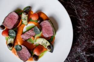 Lamb saddle, red pepper purée, black garlic, eggplant, seasonal vegetables.